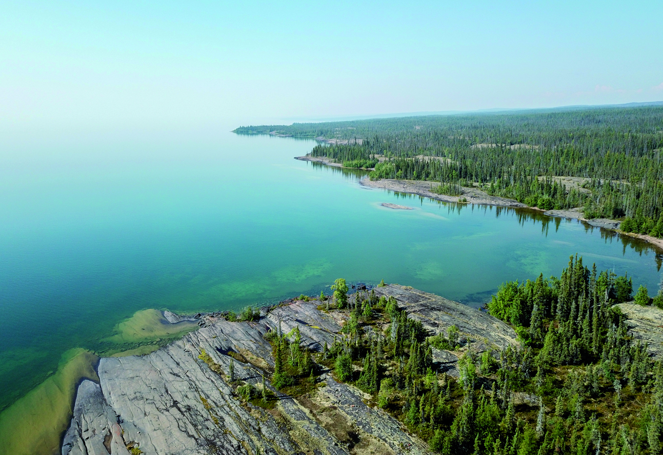 Le Grand lac des Esclaves a une cote rocheuses parsemée d'épinettes et des eaux turquoises. Il s'étend à perte de vue.